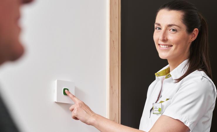 Televic Healthcare AQURA Essentials nurse pushing green button